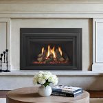 Cozy modern fireplace with decorative logs, white flowers in vase, and books on table in elegant living room.