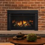 Cozy fireplace with warm flames on brick wall backdrop, enhanced by decorative moss and logs on a wooden mantel.