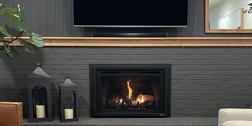 Modern living room with a sleek fireplace, lanterns, and a TV above, creating a cozy ambiance.