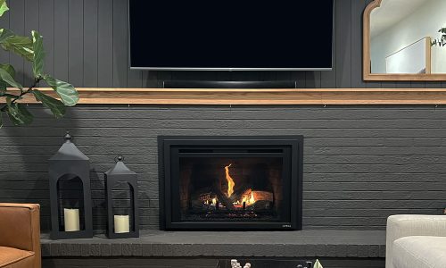 Modern living room with a sleek fireplace, lanterns, and a TV above, creating a cozy ambiance.