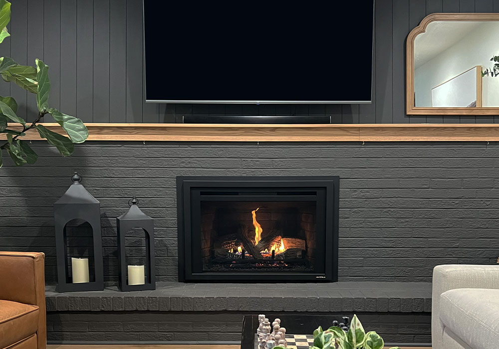 Modern living room with a sleek fireplace, lanterns, and a TV above, creating a cozy ambiance.