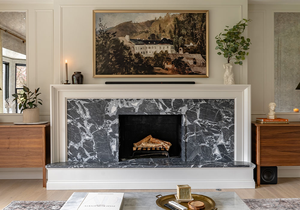Elegant modern living room with dark marble fireplace, framed artwork, and minimalist decor for a cozy ambiance.